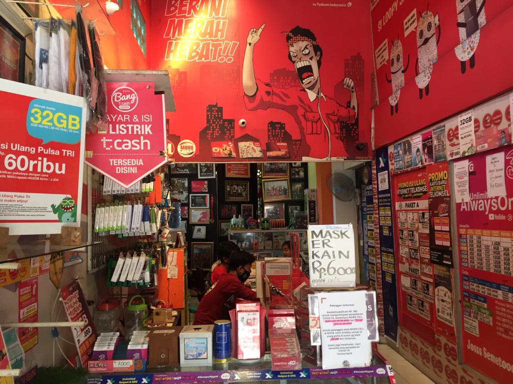 MELAYANI PEMBELI : Sejumlah karyawan konter penjualan pulsa dan paket data di kawasan Kekalik melayani pembeli, kemarin (21/6/2020).