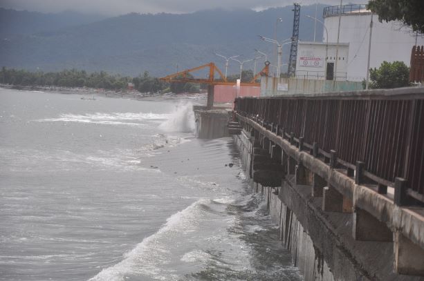 CUACA BURUK: Seorang anak duduk santai saat gelombang cukup tinggi di Pantai Boom Ampenan, belum lama ini.(Jay/Lombok Post)
