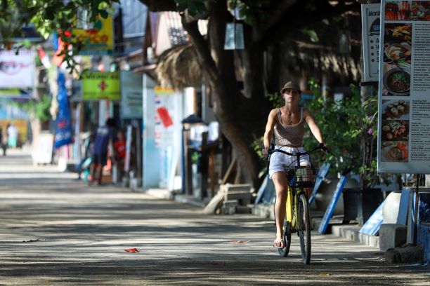 BERSEPEDA: Seorang wisatawan mancanegara sedang bersepeda di Gili Trawangan, Lombok Utara sebelum pandemi covid-19. (Ivan/Lombok Post)
