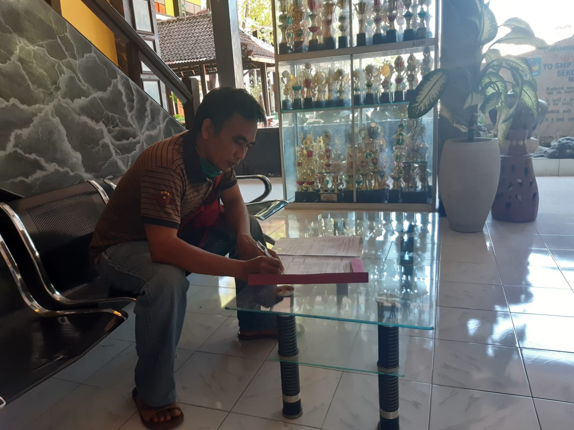 ISI BERKAS: Seorang warga mengisi berkas pendaftaran PPDB dari jalur afirmasi di SMPN 2 Mataram, beberapa waktu lalu.