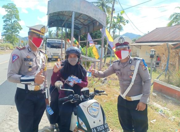 HARUS DITIRU: Kasatlantas Polres Sumbawa Barat AKP Putu Gede Caka (kanan) memberikan kupon hadiah kepada para pengendara yang mematuhi aturan lalu lintas dan protokol kesehatan, Kamis  (23/7).( POLRES SUMBAWA BARAT FOR LOMBOK POST)