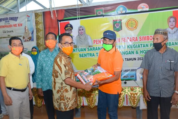 SERAHKAN BANTUAN: Wali Kota Bima H. Muhammad Lutfi menyerahkan bantuan bibit kepada petani di aula Sekolah Alam Kelurahan Kodo, Kecamatan Rasanae Timur, Kota Bima, Jumat (17/7) (HUMAS PEMKOT BIMA FOR LOMBOK POST)