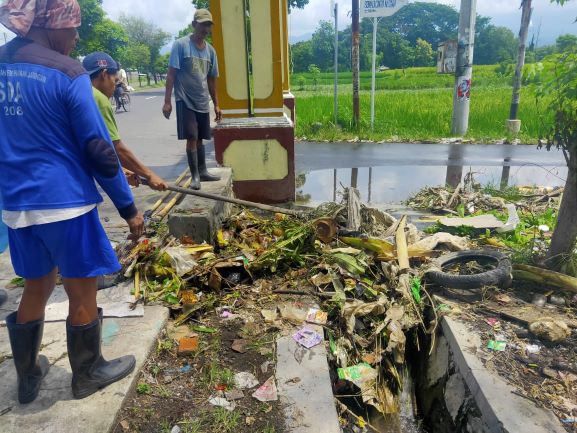 BERSIHKAN DRAINASE: Petugas dari Dinas PUPR Kota Mataram membersihkan saluran air dari sampah, belum lama ini.(dok. Lombok Post)
