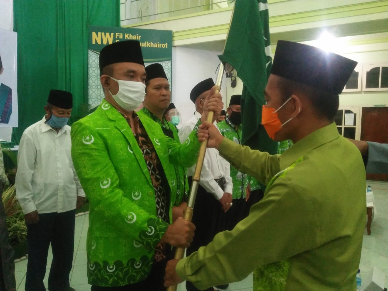 KUKUHKAN: Sekretaris Umum PW NW NTB H Irzani saat menyerahkan bendera NW kepada Ketua Umum PD NW Lotim HM Syamsul Luthfi (kiri) di aula birrulwalidain YPH PPD NW di Pancor, Sabtu (16/8/2020).