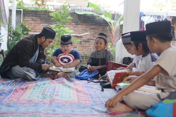 RUMAH TAHFIDZ: Ustad Akhyarosidi (paling kiri) sedang mengajarkan anaknya mengaji sebelum memulai pembelajaran di rumah tahfidz Darul Quran Al Musthofa, lingkungan Bagik Longgek Timur, Kelurahan Rakam, Selasa (25/8). (Fatih/Lombok Post)