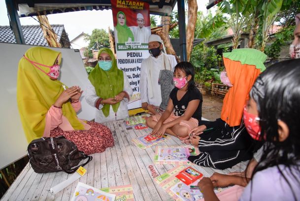 JITU ATASI MASALAH PENDIDIKAN: Hj Putu Selly Andayani dan TGH Abdul Manan, menyapa dari dekat anak-anak yang sedang dibimbing guru keliling di Lingkungan Sintung, Kelurahan Banjar, Kota Mataram, kemarin (10/8).( KUS/LOMBOK POST)