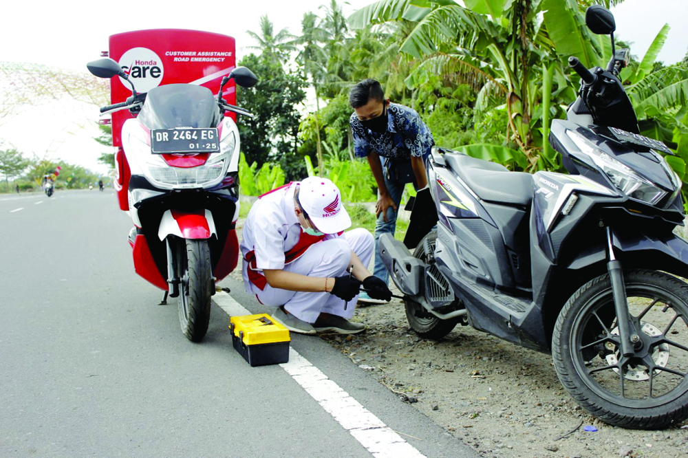 PELAYANAN PRIMA: Mekanik Honda saat melayani konsumen Honda yang mogok di jalan.