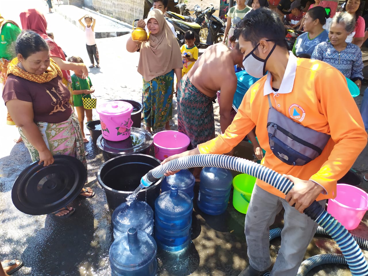 DROPING AIR: Anggota BPBD Lombok Timur membagikan air bersih kepada warga terdampak kekeringan.