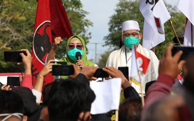 ORASI POLITIK: Bakal Calon Wali Kota Mataram Hj Putu Selly Andayani saat berorasi politik sebelum mendaftar di KPU, Sabtu (5/9). Tampak bendera PKS sebagai salah satu partai pengusung dikibarkan di samping Selly. (IVAN/LOMBOK POST)