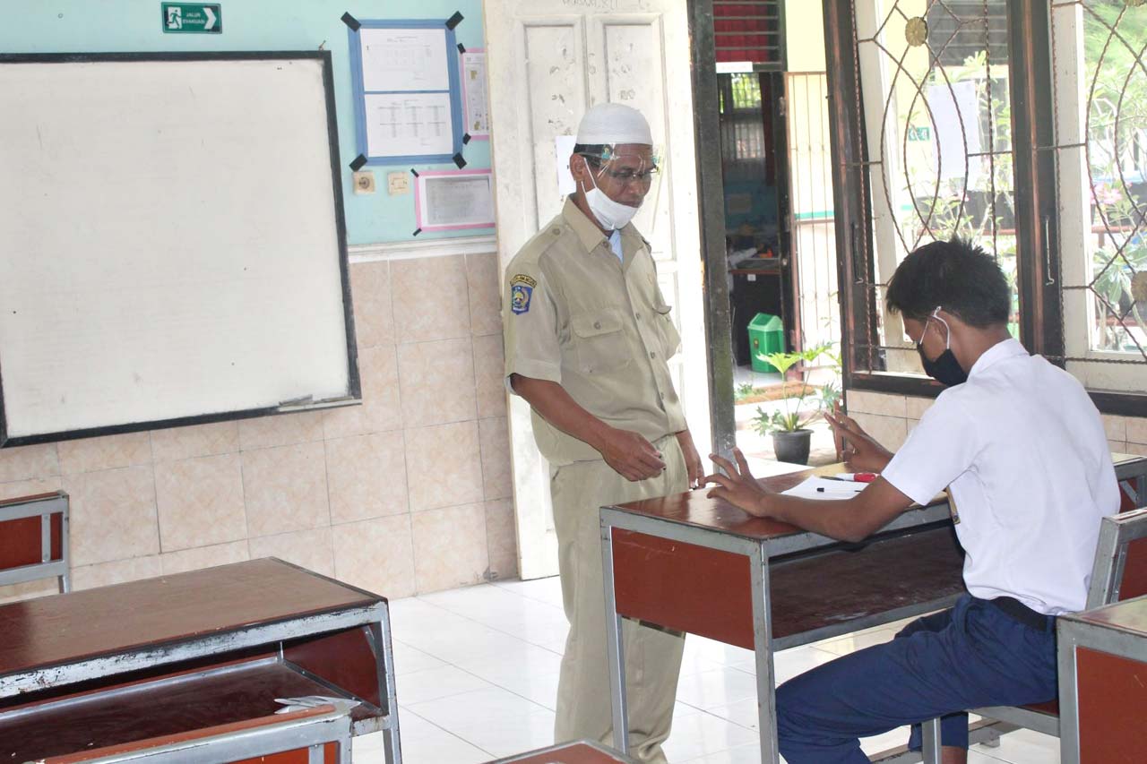FOKUS BELAJAR: Seorang guru dengan serius mengajarkan siswanya, pada simulasi KBM tatap muka di SLBN 2 Mataram, kemarin (21/9/2020).