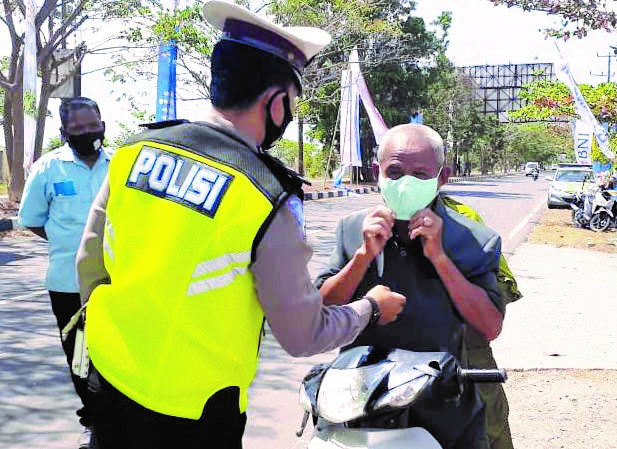 AYO PAKAI MASKER: Setiap pengendara yang melintas di jalan utama bandara dan tidak memakai masker dihentikan aparat kepolisian (7/9/20) lalu. Mereka diingatkan agar mematuhi protokol kesehatan dan kemudian diberikan masker gratis. (POLRES LOTENG FOR LOMBO