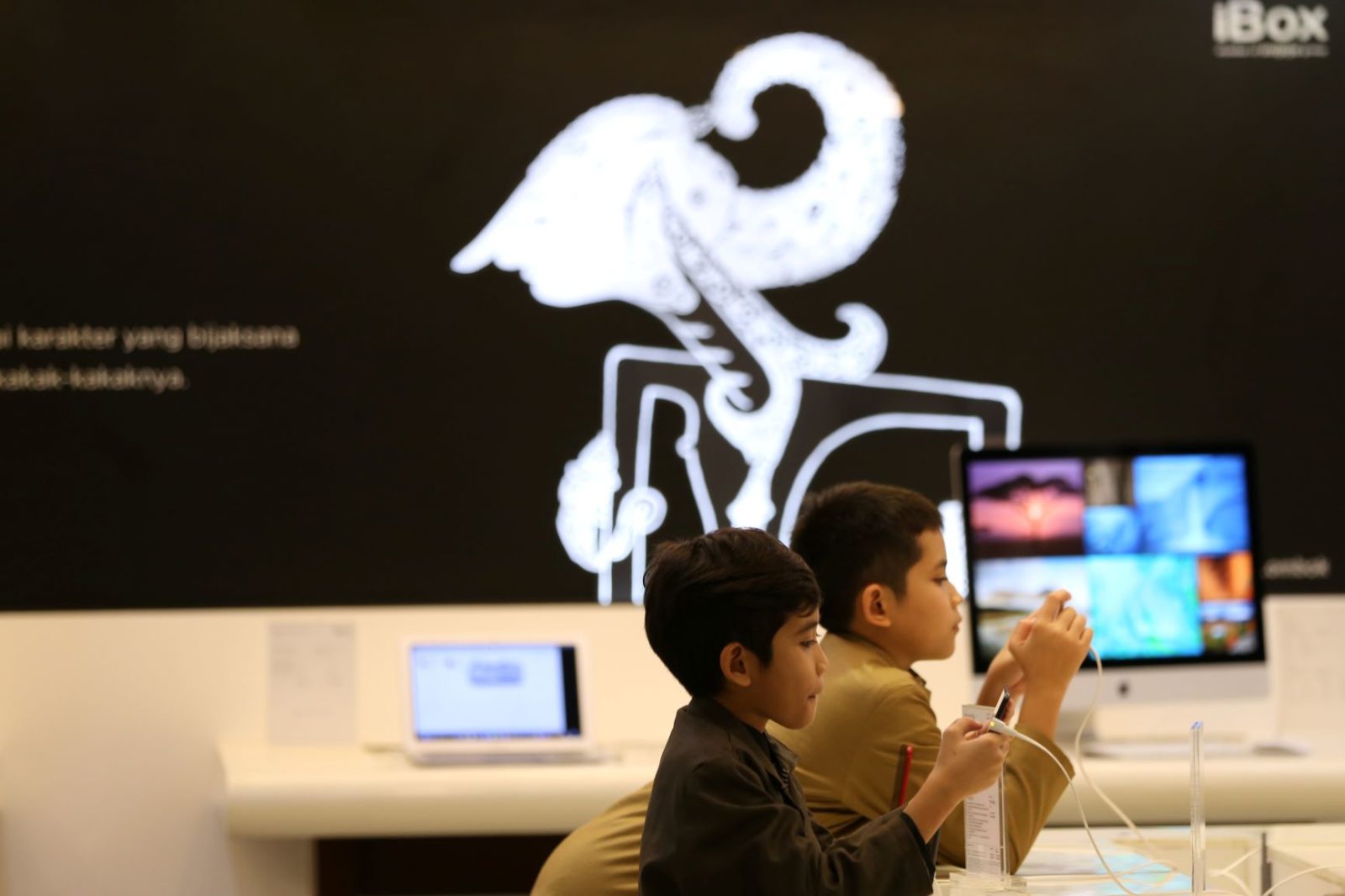 MAIN HP: Dua anak asyik memainkan ponsel pintar di Lombok Epicentrum Mall (LEM), beberapa waktu lalu.