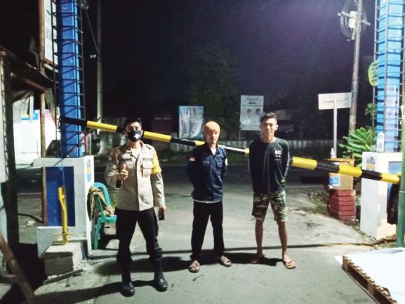 AMAN DARI KORONA: Dua orang Satgas Keamanaan Gubuk Dasan Cermen bersama pihak kepolisian berjaga di pintu masuk wilayah setempat sebagai bagian dari antisipasi penyebaran Covid-19 di Kelurahan Dasan Cermen.( HENI UNTUK LOMBOK POST)