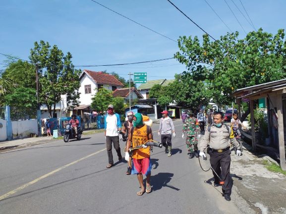 LAWAN COVID-19: Masyarakat Kelurahan Dorotangga bersama  Babinsa dan Bhabinkamtibmas gotong royong menyemprotkan desinfektan di setiap rumah.( DEDI FOR LOMBOK POST)