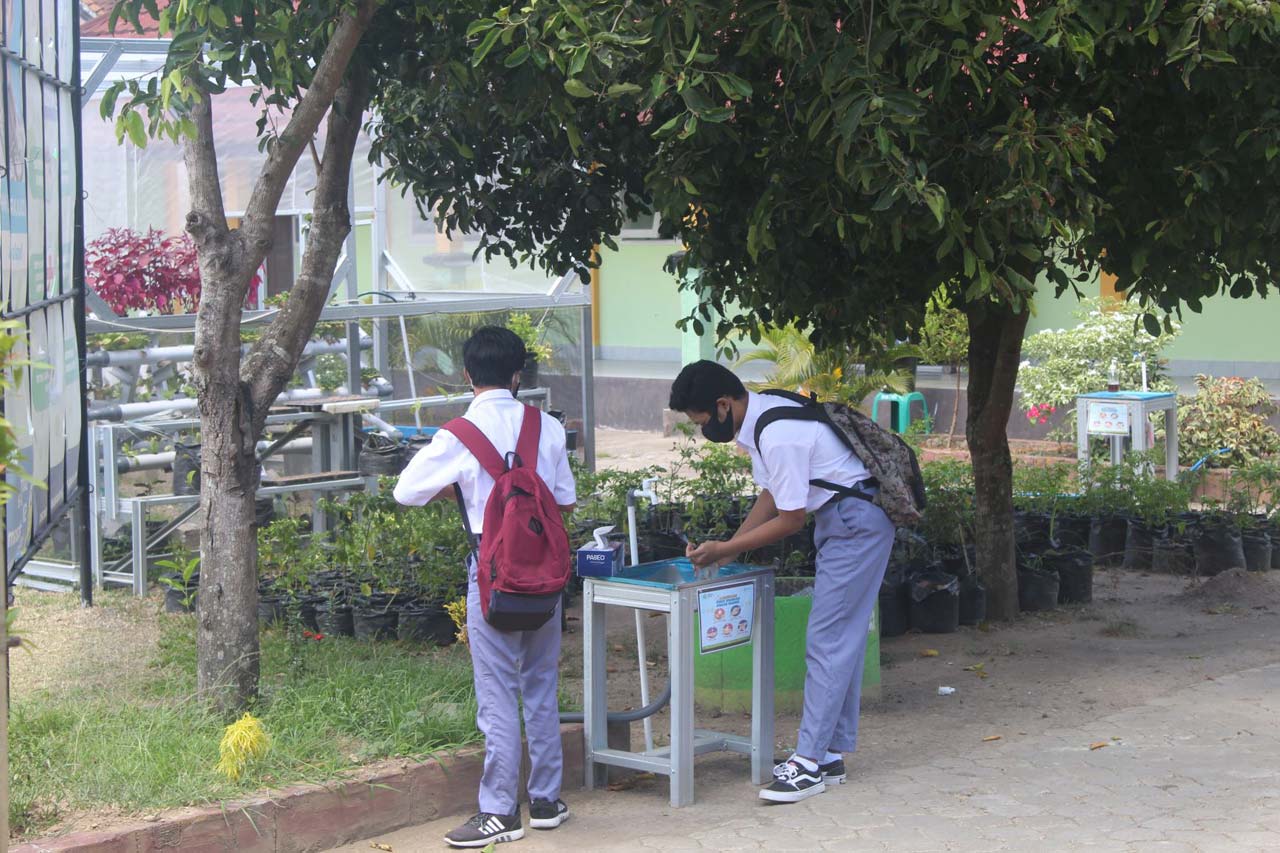 PROTOKOL KESEHATAN: Dua siswa (kanan) mencuci tangan sebelum masuk kelas untuk simulasi belajar tatap muka, di SMKN 7 Mataram, akhir September lalu.