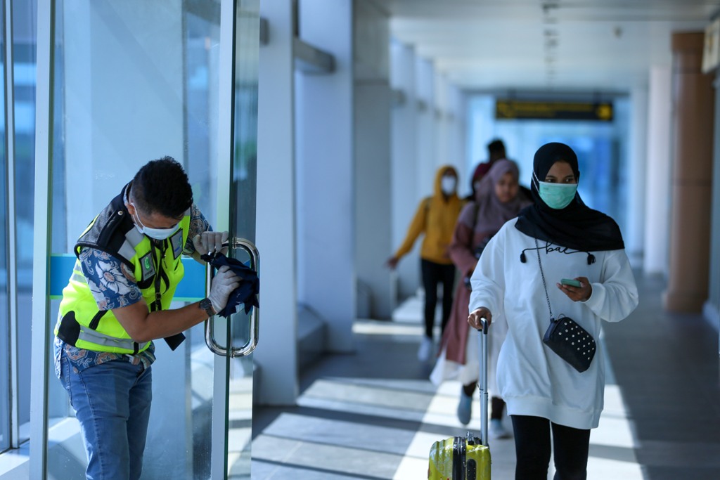 TETAP PATUHI PROKES: Tampak sejumlah penumpang sedang menuju pesawat di bandara, belum lama ini. Pelaku perjalanan diminta untuk tetap menjalankan prokes di saat bepergian hingga tiba di tujuan.