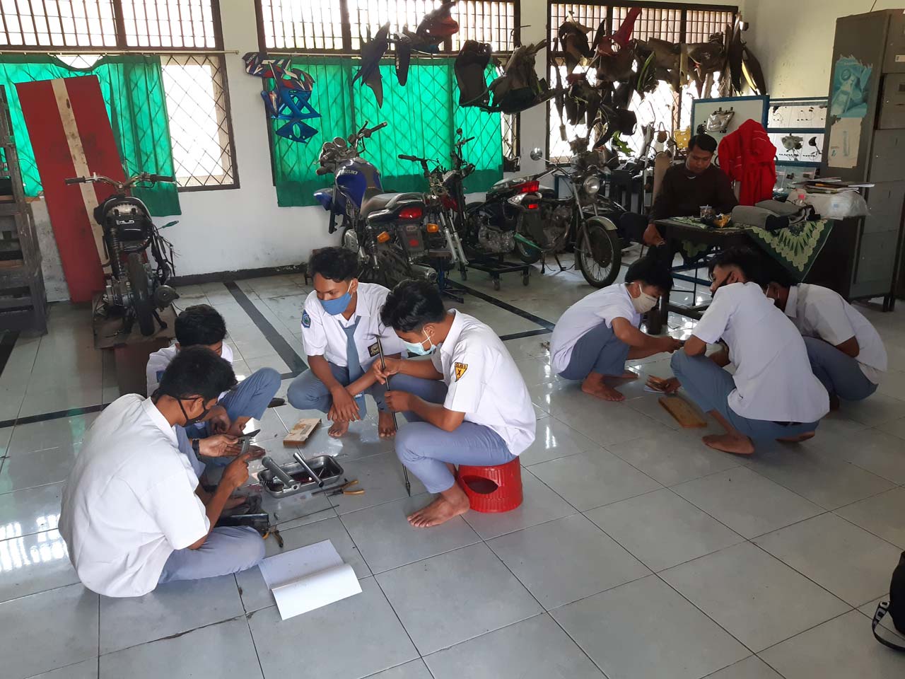 ASAH KEMAMPUAN: Sejumlah siswa SMKN 5 Mataram dari kompetensi keahlian Teknik dan Bisnis Sepeda Motor (TBSM), melakukan praktik, diawasi gurunya, September lalu.