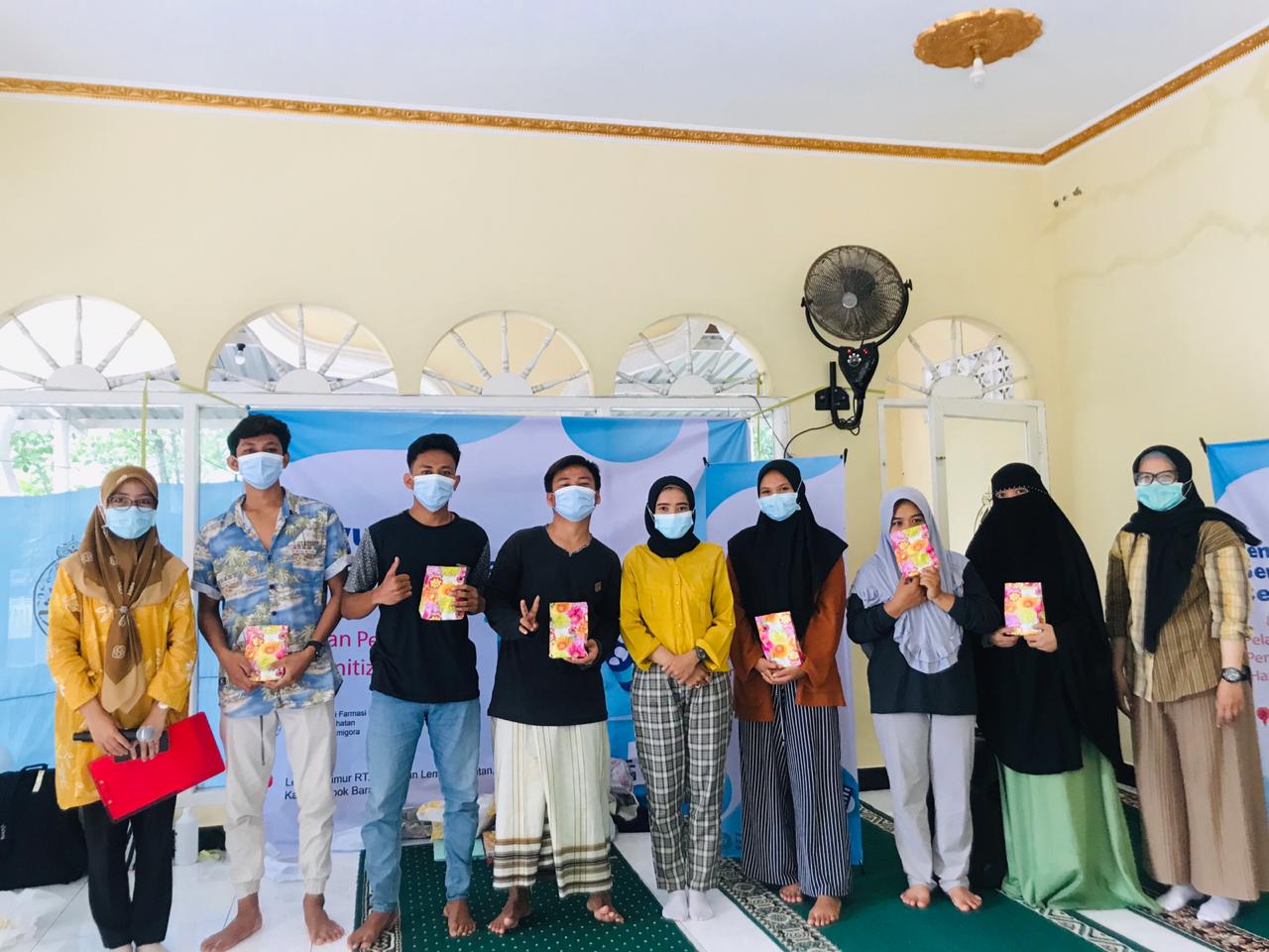 TERIMA BINGKISAN: Peserta penyuluhan ”Gema Cermat Obat dan Pelatihan Pembuatan Hand Sanitizer” di Dusun Lembar, Desa Lembar Selatan, Kecamatan Lembar bersama tim dosen Program Studi Farmasi, Fakultas Kesehatan, Universitas Bumigora, Sabtu (5/12/2020) lalu