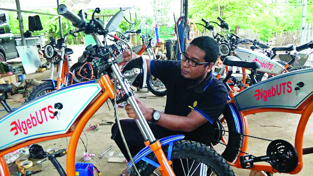 FINISHING: Ahmad Jaya, ketua tim produksi NgeBUTS merampungkan produksi salah satu sepeda listrik NgebUTS.