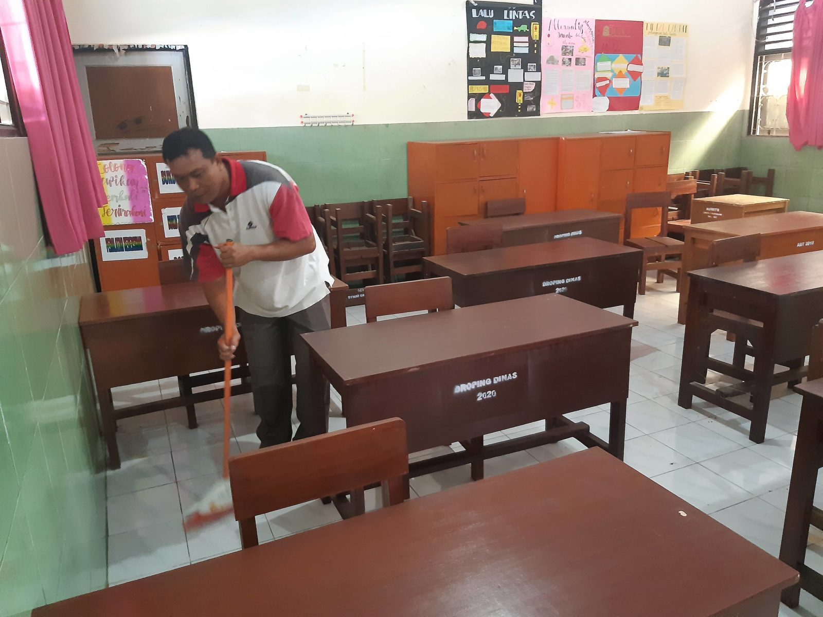 PERSIAPAN : Seorang staf membersihkan salah kelas di SMPN 2 Mataram, yang akan digunakan siswa,  (13/1).