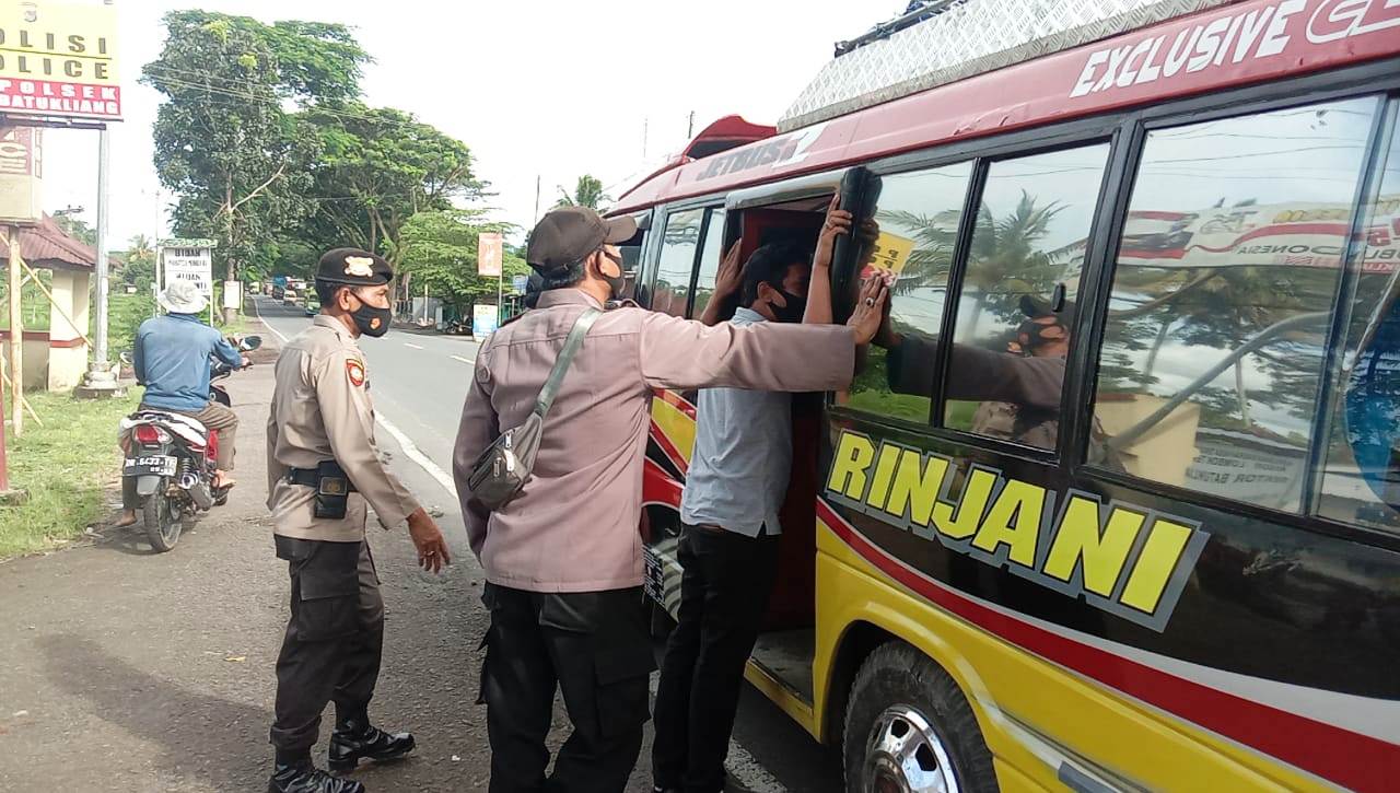 DIPERIKSA: Personel Polsek Batukliang saat memeriksa seluruh penumpang kendaraan, apakah pakai masker atau tidak, Jumat (28/1). (Foto: Dedi/Lombok Post)