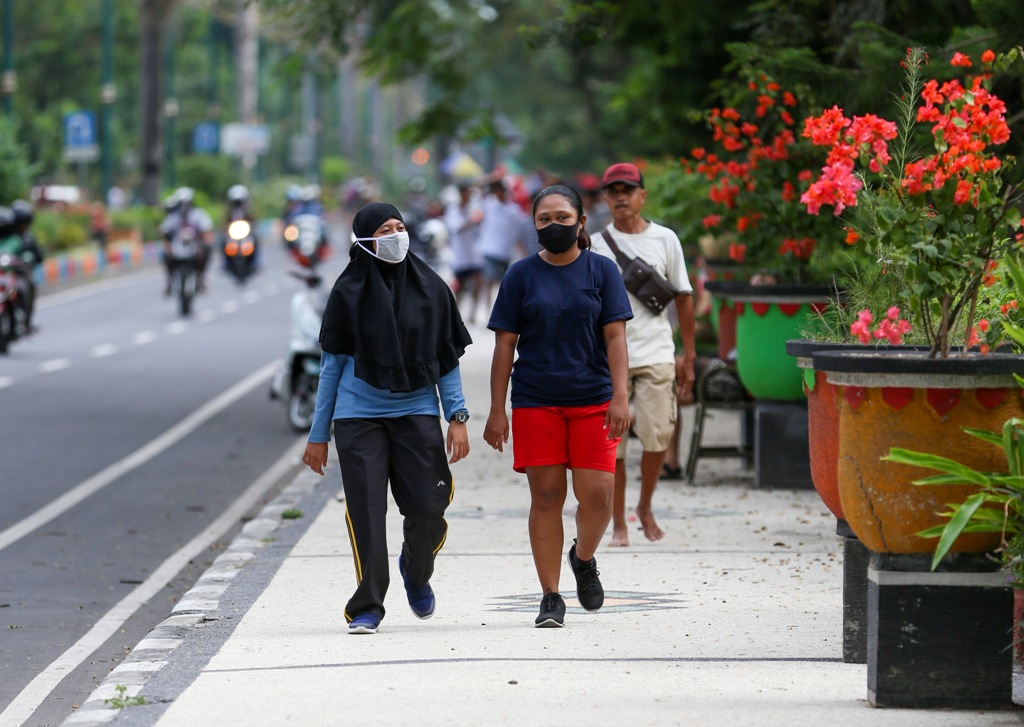 TETAP PATUHI PROTOKOL KESEHATAN: Tampak dua orang warga tetap memakai masker saat berolahraga. Meski sudah ada vaksin, masyarakat diharapkan bisa tetap menerapkan protokol kesehatan. (Foto: Ivan/Lombok Post)