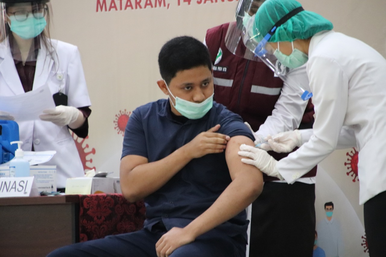 SUNTIK VAKSIN: Zulfikar, anak Gubernur NTB H Zulkieflimansyah, sebagai perwakilan milenial saat disuntik Vaksin Sinovac, di Mataram, kemarin (14/1).