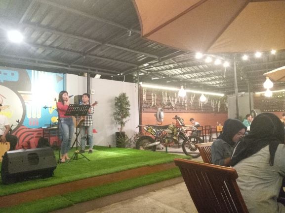 MENGHIBUR: Seorang penyanyi (baju merah) membawakan lagu untuk menghibur para pengunjung di Kafe Meekow, Pagutan, Kota Mataram, Rabu malam (6/1) lalu .( ROJAI/LOMBOK POST)