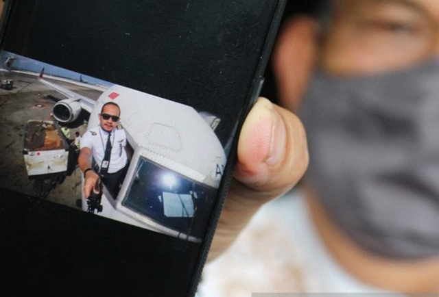 Sumarzen Marzuki menunjukkan foto putra bungsunya Fadly Satrianto yang bekerja sebagai Co-Pilot di maskapai penerbangan Nam Air, anak perusahaan Sriwijaya Air. (ANTARA Jatim/Didik Suhartono)