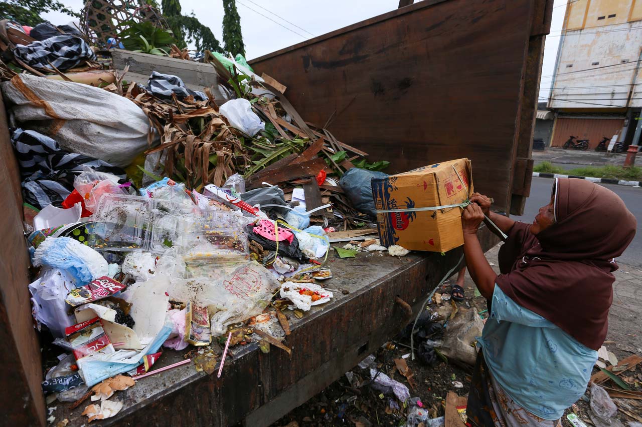 AKAN DITUTUP: Seorang pemulung membuka kardus berisi sampah di salah satu TPS di Kota Mataram, Selasa (19/1/2021). DLH akan maksimalkan penanganan sampah dengan TPS keliling.