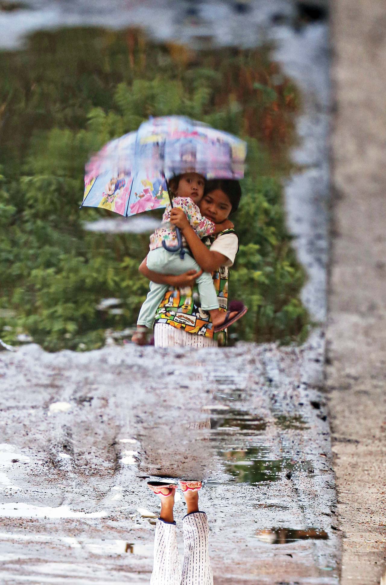 HATI-HATI DBD: Seorang anak menggendong adiknya melewati genangan air di Dasan Agung, Kota Mataram, belum lama ini. Awal tahun ini terjadi dua kasus DBD.