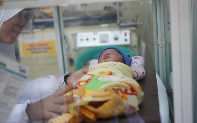 ILUSTRASI: Seorang petugas medis di ruang neonatus RSUD dr Raden Soedjono Selong sedang merawat bayi yang baru lahir. (Foto: Fatih/Lombok Post)