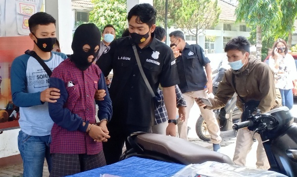 DITANGKAP POLISI: EB (menggunakan tutup kepala), warga Desa Aikmual, Praya Loteng yang merupakan salah seorang terduga pelaku pembunuhan berencana saat ditangkap polisi, Kamis (4/2). (Foto: Dedi/Lombok Post)