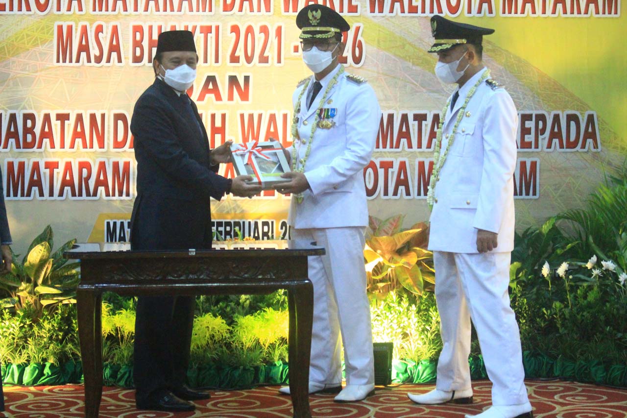 SERAH TERIMA JABATAN: Sekretaris Daerah Kota Mataram H Effendi Eko Saswito yang sempat menjabat Plh Wali Kota menyerahkan jabatan kepada Wali Kota Mataram terpilih H Mohan Roliskana dan Wakilnya TGH Mujiburrahman usai pelantikan, Jumat (26/2/2021).