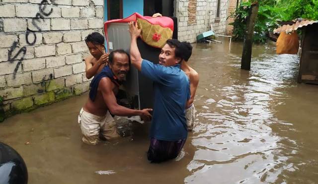 TERENDAM BANJIR: Warga Lingkungan Leneng, Kelurahan Leneng, Kecamatan Praya, Loteng saat menyelamatkan harta benda mereka dari banjir, Jumat (26/2). (Dedi/Lombok Post)