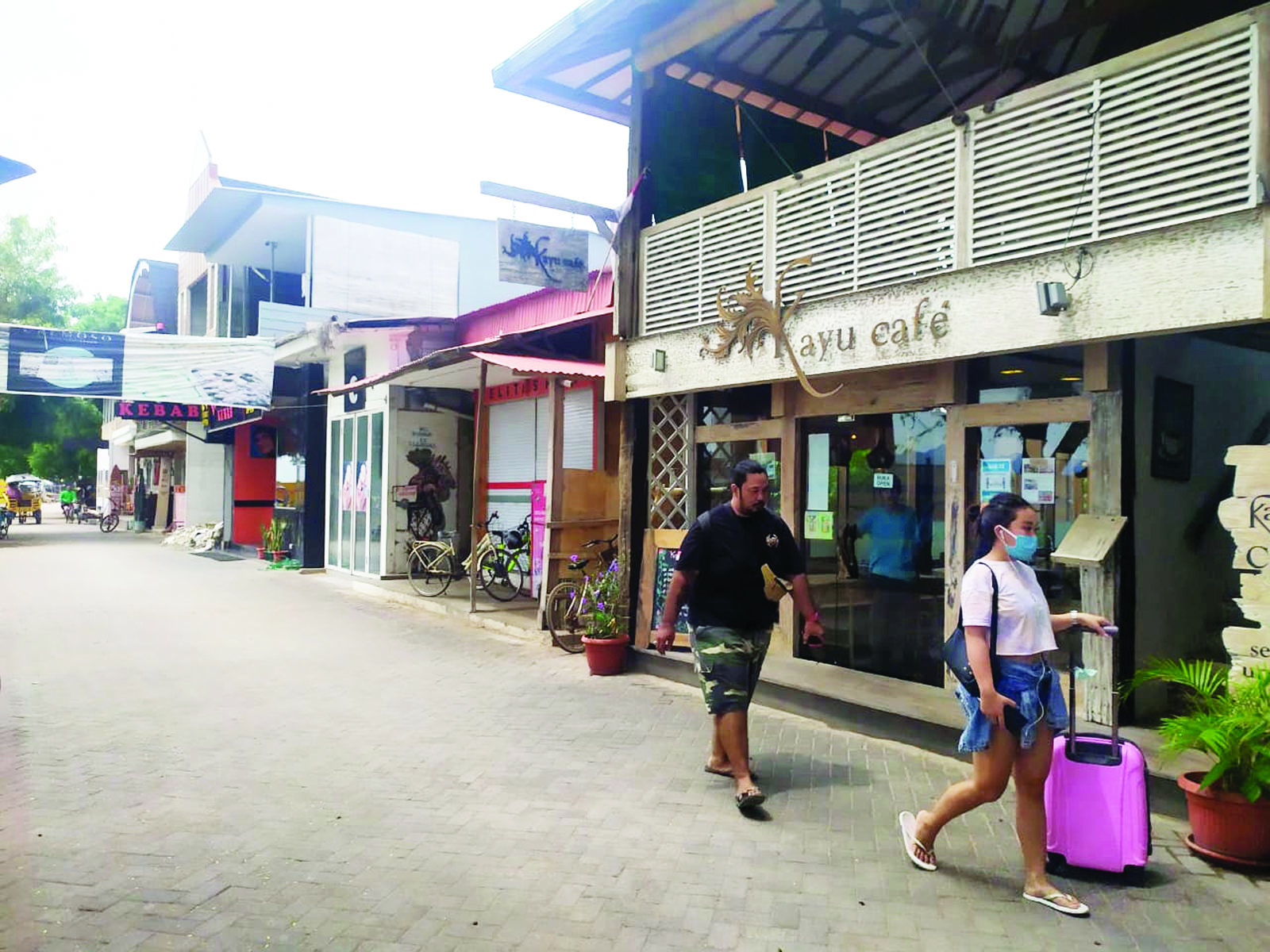 PERSOALAN LAHAN: Dua orang wisatawan berjalan di depan hotel yang berdiri di atas lahan Pemprov NTB yang dikerjasamakan dengan PT GTI di Gili Trawangan, beberapa waktu lalu. (Dok/Lombok Post)