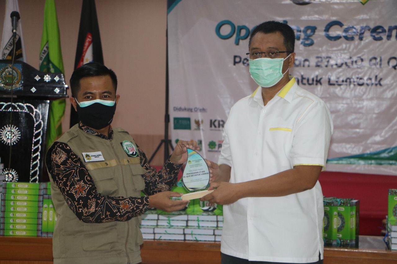 WAKAF ALQURAN: Gubernur NTB H Zulkieflimansyah (kanan) menerima cenderamata dari Direktur Yayasan Amirul Ummah Indonesia Irfan Ahmad Fauzi sebagai simbolisasi pendistribusian 27 ribu mushaf Alquran dari NGO Iman Care asal Malaysia melalui Yayasan Amirul I