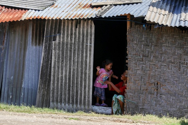 POTRET KEMISKINAN NTB: Seorang nenek bergurau dengan cucunya di pintu rumahnya yang terbuat dari asbes dan anyaman bambu di Kelurahan Bintaro, Kota Mataram, Selasa (16/2). (Foto: Ivan/Lombok Post)