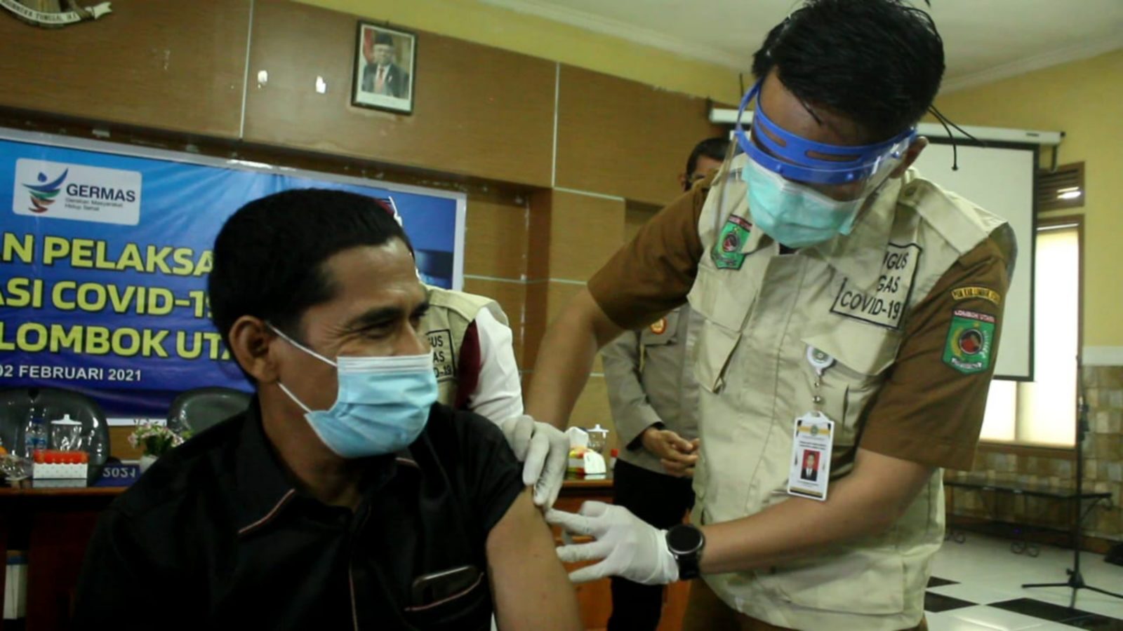 VAKSINASI PERDANA: Ketua DPRD KLU Nasrudin mendapat jatah vaksinasi perdana bersama 19 orang lainnya, di aula bupati KLU, (2/2).