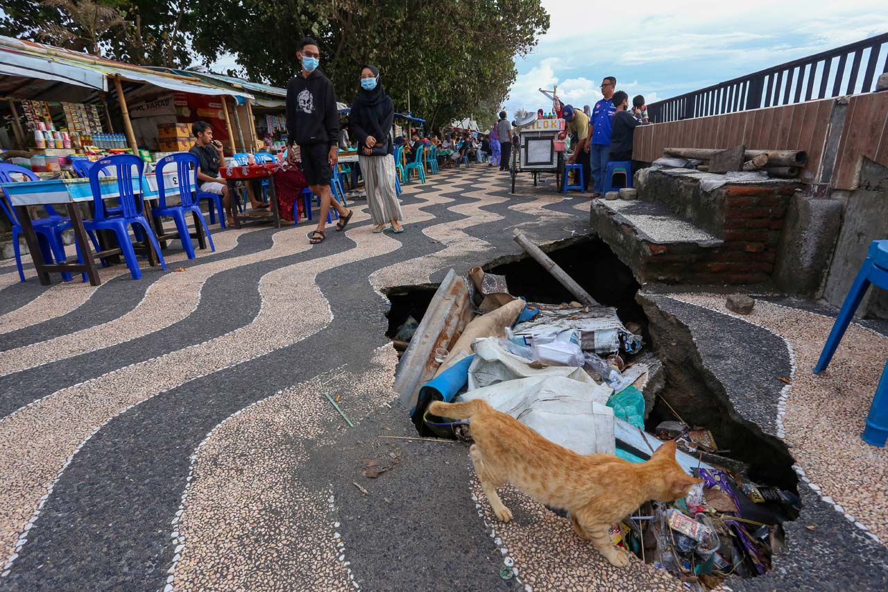 BERBAHAYA: Beginilah kondisi lubang yang menganga di Pantai Ampenan, kemarin. Sekilas jalan ini baik-baik saja tetapi tanah di dalamnya berlubang akibat abrasi sehingga sangat berbahaya.