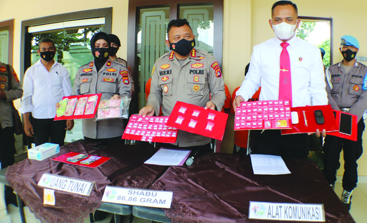 INI BUKTINYA: Kapolresta Mataram Kombes Pol Heri Wahyudi (tengah) didampingi Kasatresnarkoba AKP I Made Yogi Purusa Utama (kanan) menunjukkan barang bukti milik tiga IRT yang ditangkap di Karang Bagu, Senin (22/3/2021). (Harli/Lombok Post)