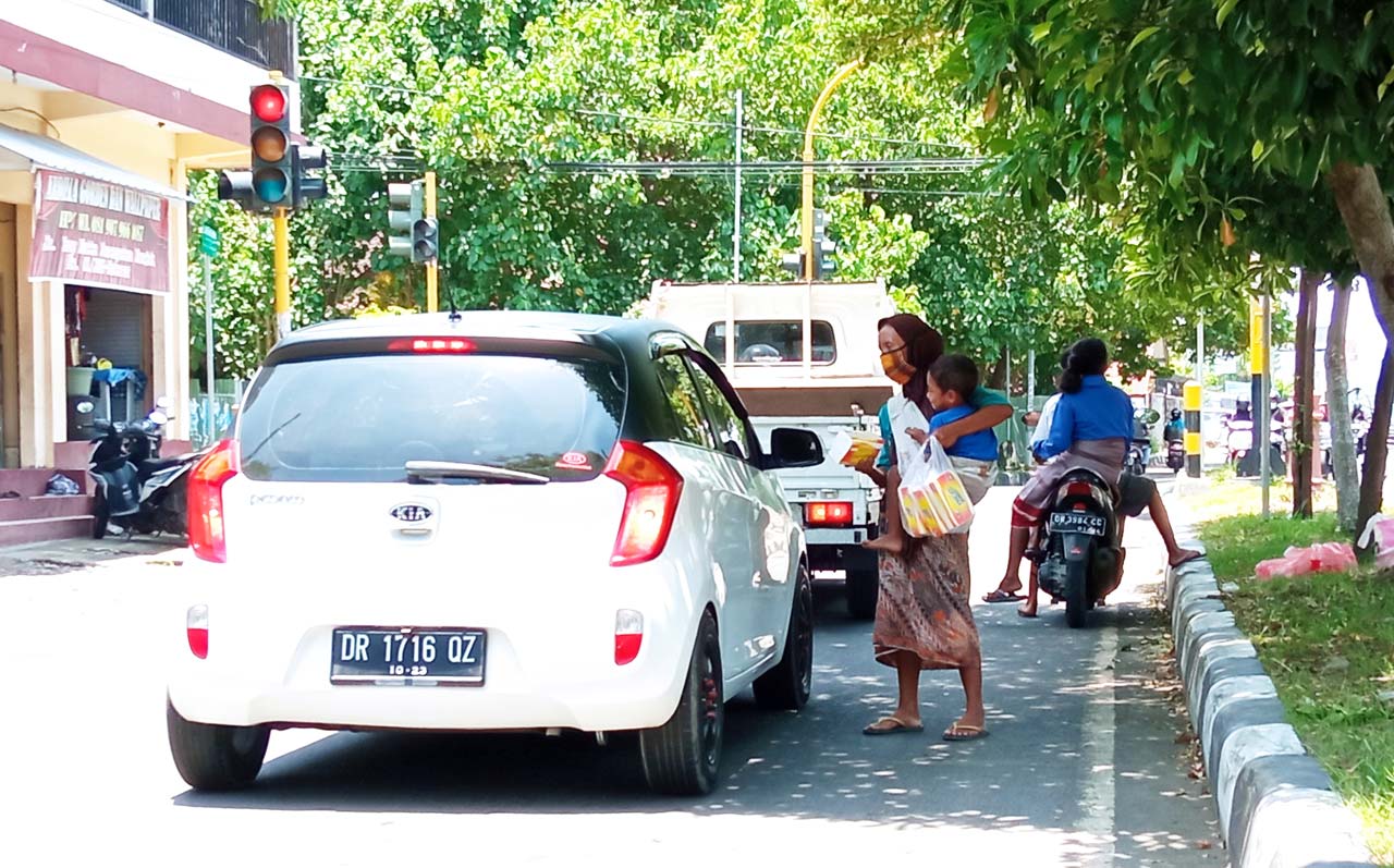 HARUS DIPERHATIKAN: Salah satu warga menjual tisu di perempatan Jalan Bung Hatta belum lama ini.