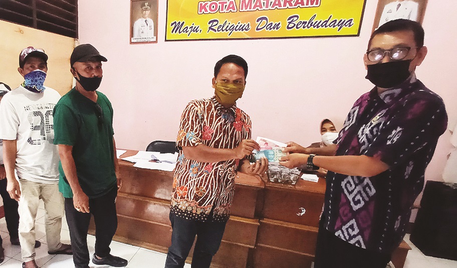 TERIMA INSENTIF: Lurah Karang Taliwang Lalu Ahmad Cahyadi menyerahkan insentif kepada para ketua RT di kantor lurah setempat, Kamis (25/3/2021). (Toni/Lombok Post)