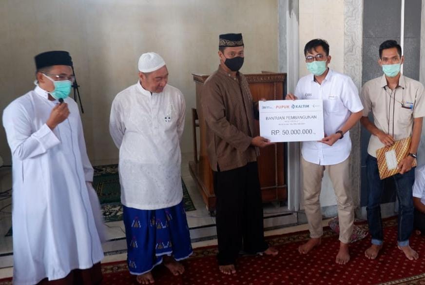 SERAHKAN BANTUAN: Perwakilan Pupuk Kaltim NTB Muhammad Hidayah Syam (dua dari kanan) saat menyerahkan bantuan ke pengurus Masjid Babussalam di Kota Bima, Jumat (5/3/2021).