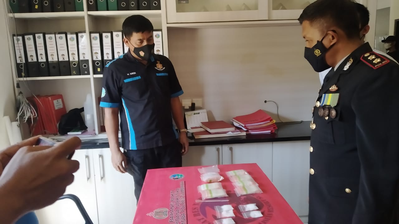 CEK BARANG BUKTI: Kapolres Sumbawa AKBP Widy Saputra (kanan) mengecek barang bukti sabu yang disita anggota Satnarkoba dari tangan DD (inisial, Red), Kamis (25/3/2021). (Randy/Radar Sumbawa)