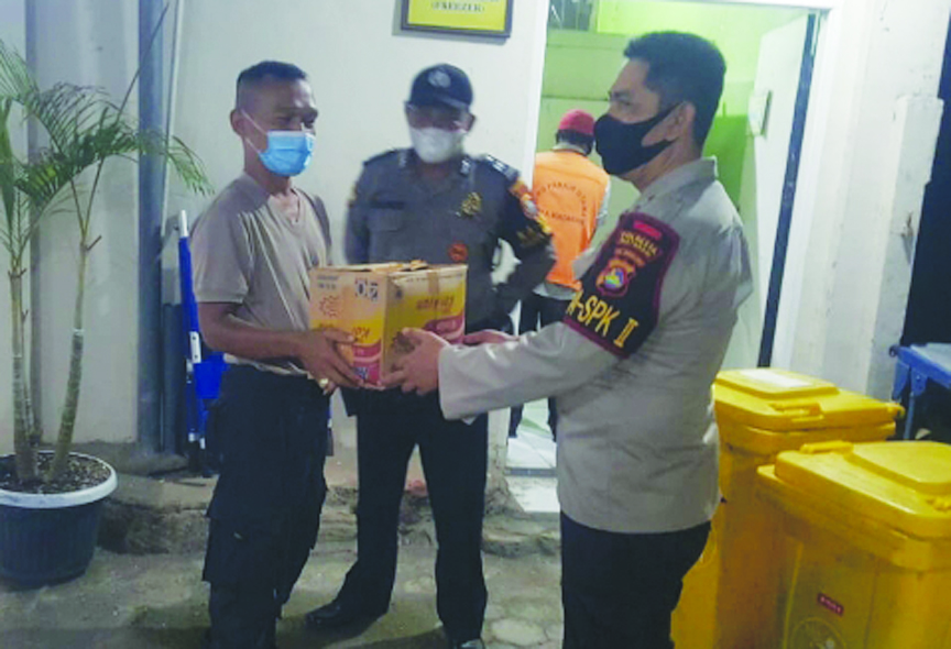 PENEMUAN MAYAT BAYI: Polisi menyerahkan kardus mi  instan berisi mayat bayi ke penjaga Rumah Sakit Bhayangkara untuk diperiksa lebih lanjut, Rabu malam (14/4/2021). (IST/Lombok Post)