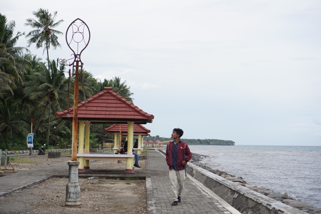 MENUNGGU DIPERBAIKI: Seorang pengunjung pantai Suryawangi melihat tiang lampu yang sudah rusak di kawasan taman wisata Suryawangi, Kelurahan Suryawangi, Kecamatan Labuhan Haji belum lama ini. (Fatih/Lombok Post)