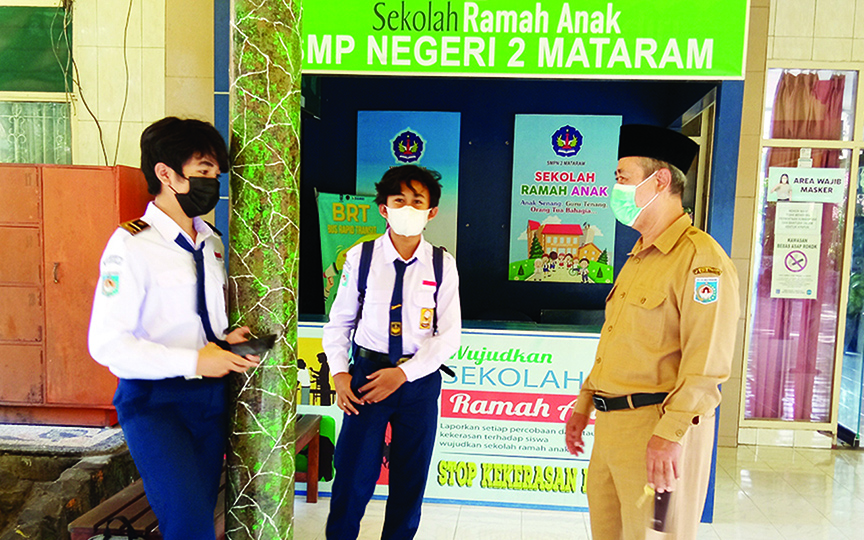 SAPA SISWA: Kepala SMPN 2 Mataram M Nazuhi (kanan) berdialog dengan siswa kelas VII yang sudah mulai masuk sekolah, Senin (19/4/2021). (Toni/Lombok Post)
