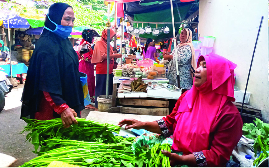 MERANGKAK NAIK: Seorang pengunjung menawar kangkung di Pasar Mandalika, Selasa (13/4/2021). Harga kangkung dan sejumlah kebutuhan pokok lainnya mengalami kenaikan di hari pertama Ramadan. (Rojai/Lombok Post)