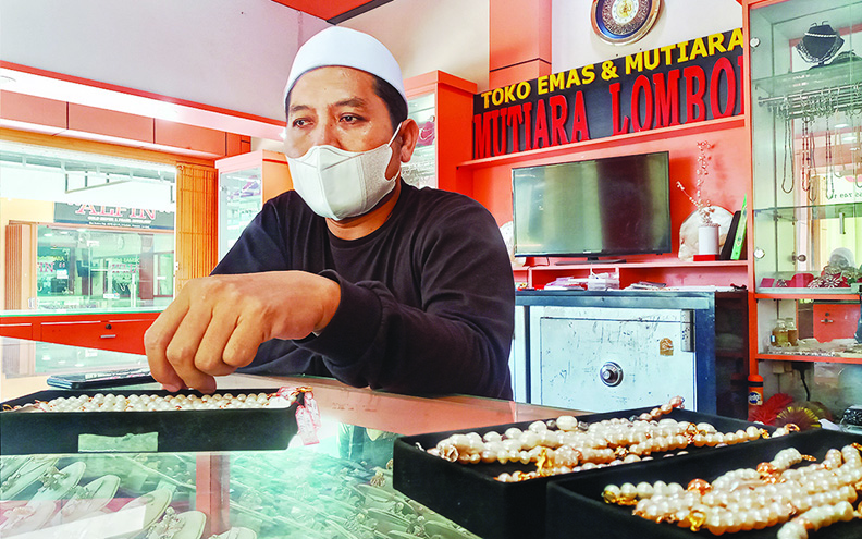 KREATIF: Owner Mutiara Lombok H Fauzi memperlihatkan konektor masker yang dibuat dari mutiara air laut di toko miliknya di Lingkungan Karang Mas Mutiara, Kelurahan Karang Pule, Kecamatan Sekarbela, Kota Mataram, Kamis (22/4/2021). (Rojai/Lombok Post)